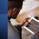 A man using a tablet to apply productivity tactics and manage his time effectively.